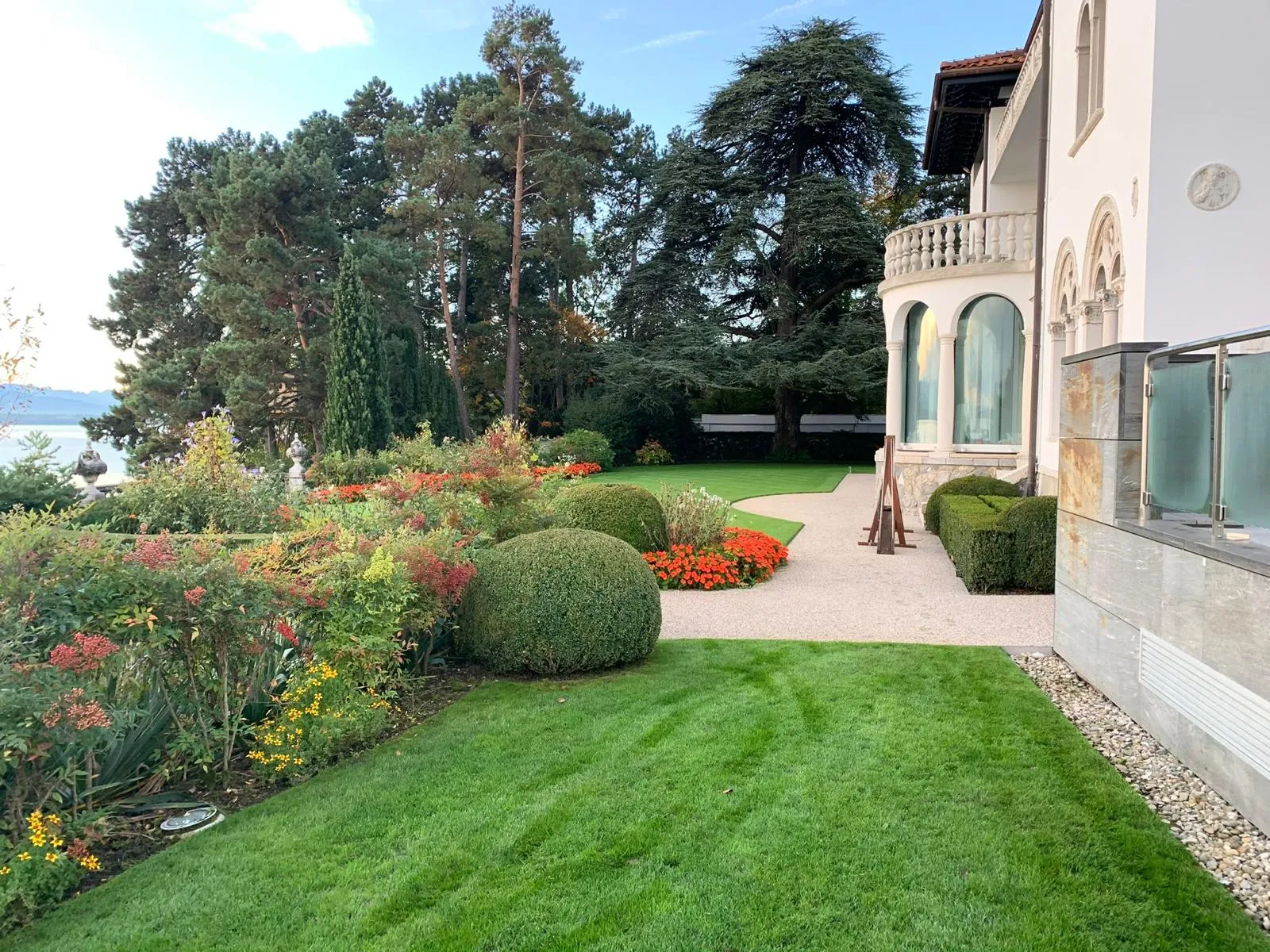 Jardin de villa avec massifs fleuris, buis taillés et pelouse
